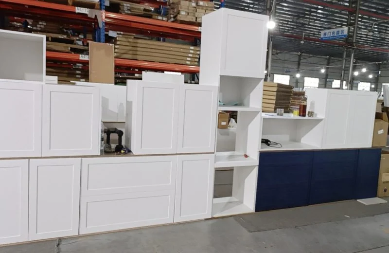 assembled RTA cabinets in white and blue with shelves and drawers displayed in warehouse setting